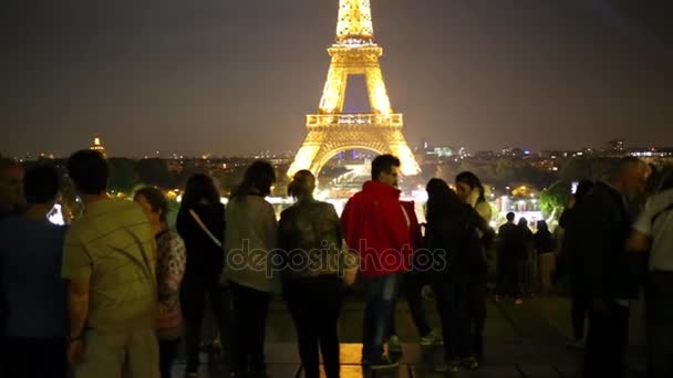 Touristen schauen sich nachts den Eiffelturm in Paris an — Stockvideo