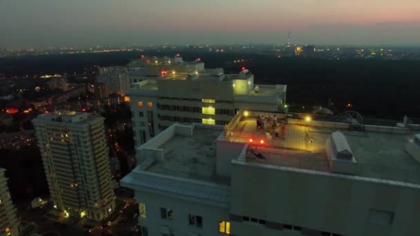 Люди получают удовольствие на крыше жилого комплекса — стоковое видео