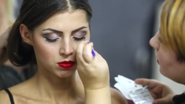 Make-up-Artist klebt falsche Wimpern, während andere Frisuren für Models machen — Stockvideo