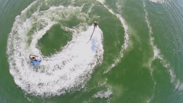 Waterbike jízdy v blízkosti člověka, který letí na vodním paprskem — Stock video