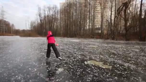 Eiskunstläuferin am zugefrorenen Teich spielt mit Ball — Stockvideo