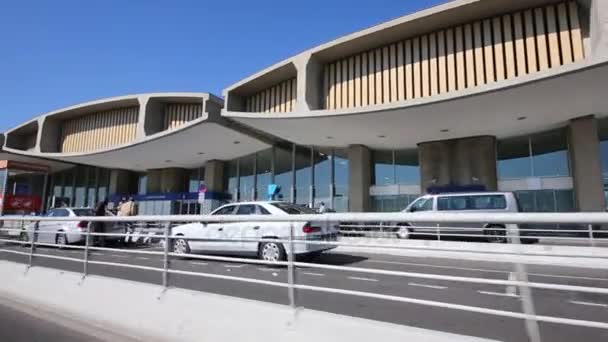 Автомобілі пересуваються по дорозі вздовж терміналів аеропорту — стокове відео