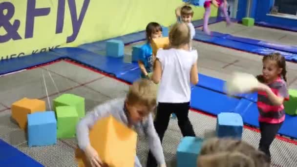 Дети играют с кубиками в клубе батутов — стоковое видео