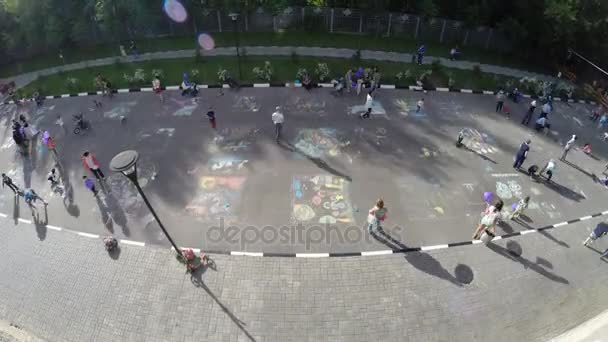 Los niños dibujan sobre dibujos de asfalto en el Día de los Niños — Vídeos de Stock