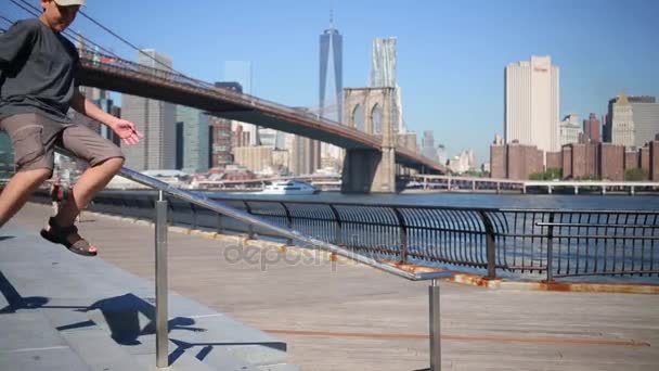 Menino desliza sobre trilhos perto de Brooklyn Bridge — Vídeo de Stock