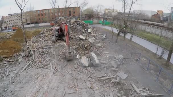 Экскаватор перемещает старые руины зданий — стоковое видео