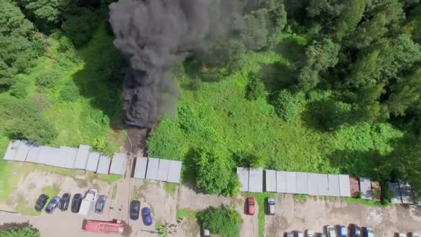 Bombeiro extingue fogo com fumaça escura — Vídeo de Stock