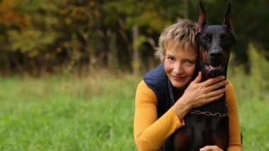 Kadın köpeğini sonbahar ormandaki kucaklayan