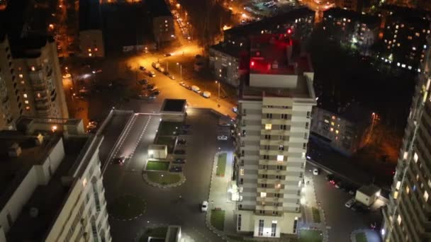 Bâtiments résidentiels avec éclairage et voitures la nuit — Video