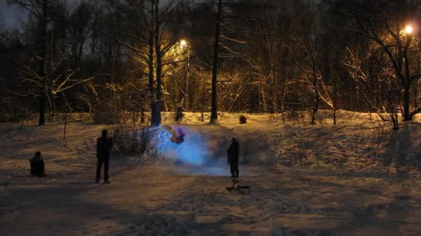 Familjer rida på uppblåsbara innerslangar på snö sluttning — Stockvideo