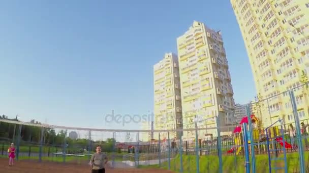 La gente juega bádminton en el patio con la red — Vídeo de stock