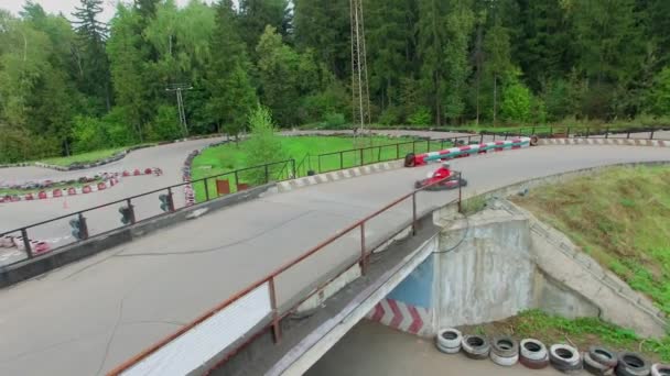 Sportsmen ride on carts by racing track — Stock Video