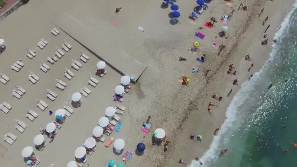 Muitas pessoas descansam na praia de areia — Vídeo de Stock