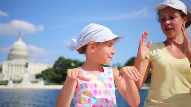 Woman with daughter depict hearts near pond and Capitol — Stock Video