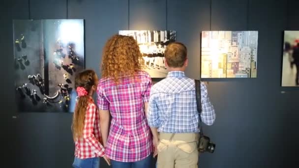 Kvinna och barn ser foton i huvudkontoret av Shutterstock — Stockvideo