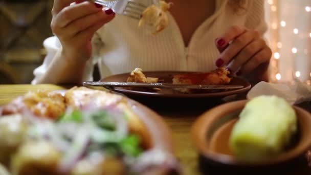 Женщина ест мясо на гриле за столом — стоковое видео