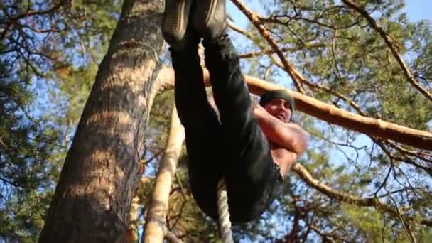 Homem de chapéu para baixo corda na floresta — Vídeo de Stock