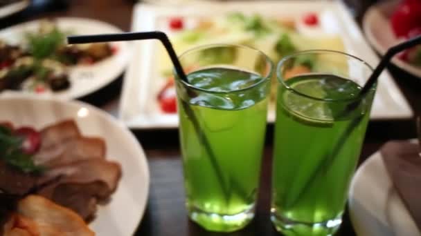 Ποτήρια κοκτέιλ με καλαμάκια στο τραπέζι στο εστιατόριο — Αρχείο Βίντεο