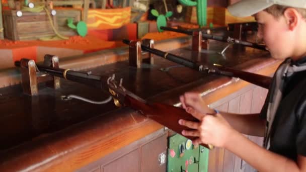 Boy holds wooden gun in shooting gallery — Stock Video