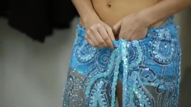 Mädchen zieht Kostüm mit Ornamenten an, fixiert Hose — Stockvideo