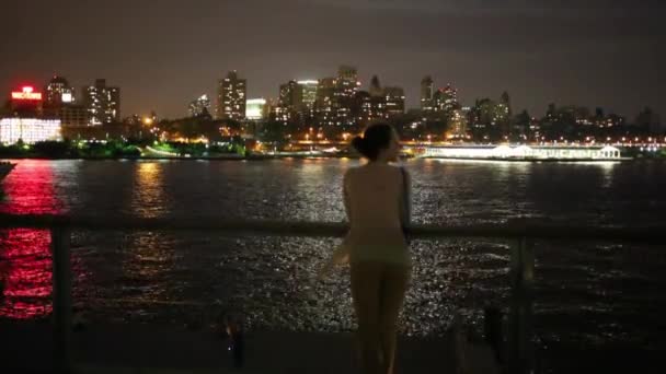 Frau steht auf Seebrücke und Mädchen kommt nachts zu ihr — Stockvideo