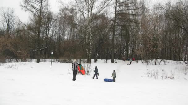 La gente monta en tubos interiores inflables en la pendiente de la nieve — Vídeos de Stock