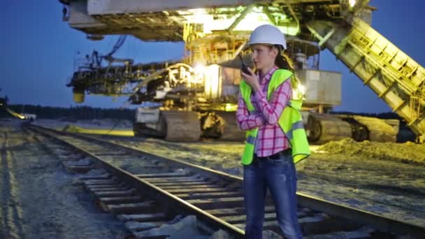 Female worker is talking on walky-talky near career stacker — Stock Video