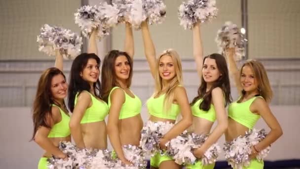 Women pose with shiny pompons in gym hall — Stock Video