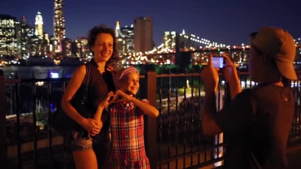 Мальчик стреляет в мать и сестру на фоне небоскребов — стоковое видео