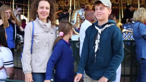 Woman with children and carousel in Disneyland — Stock Video