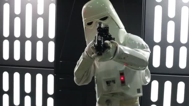 Человек в белом костюме с пистолетом на Everycon — стоковое видео