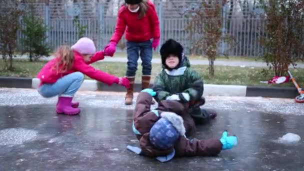 Girls and boys play on frozen puddle — Stock Video