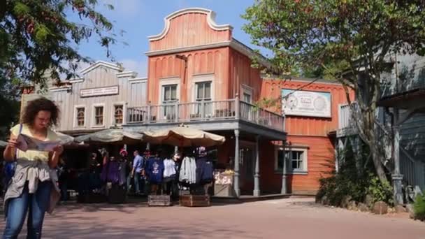 Mulher lê panfleto na Frontierland da Disneylândia em Paris — Vídeo de Stock