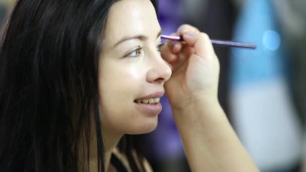 Maquillaje artista mano pinta la ceja de modelo de niña — Vídeo de stock