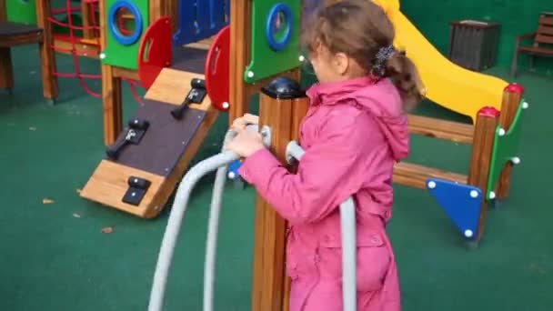 Девочка играет на современной детской площадке — стоковое видео