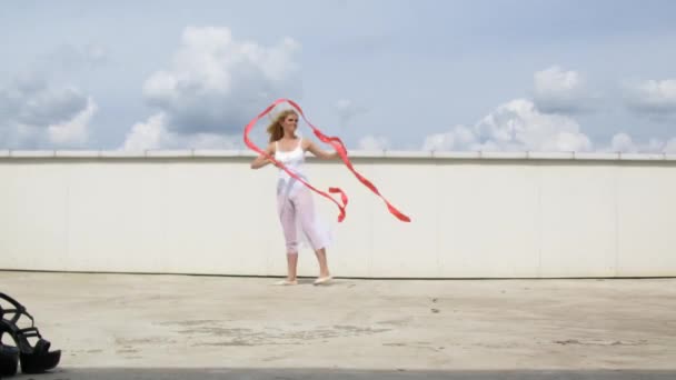 Танцовщица с лентой, позирующей на крыше для фотографа — стоковое видео