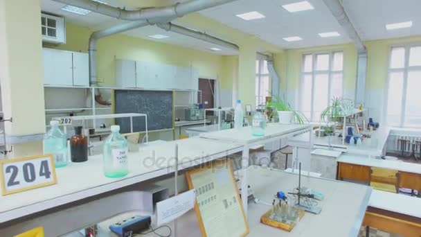 Schoolbord in laboratorium met apparaten op bureaus en reagentia — Stockvideo