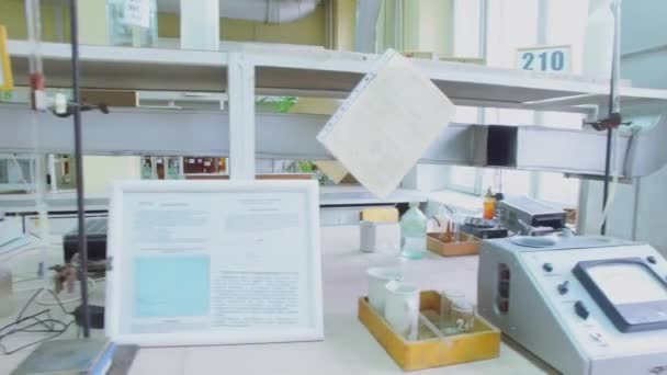 Лабораторные задачи на столах с устройствами и реагентами — стоковое видео