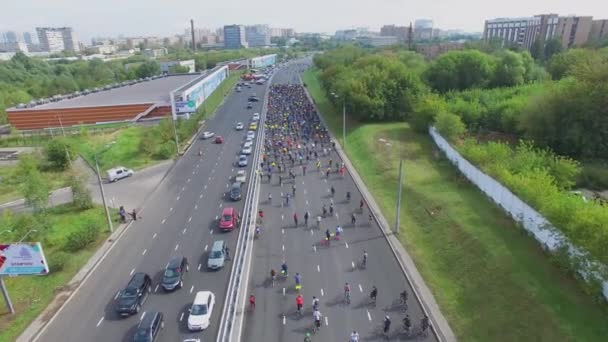 Cityscape with crowd of cyclists ride by highway — Stock Video