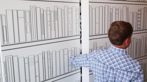 Junge öffnet Tür mit bemalten Bücherregalen — Stockvideo