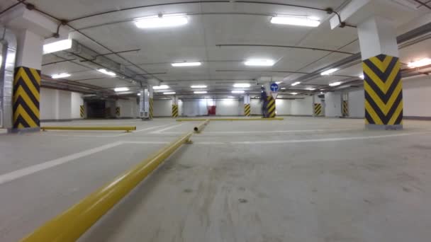 Menina rolo e seu pai patinação no estacionamento subterrâneo — Vídeo de Stock