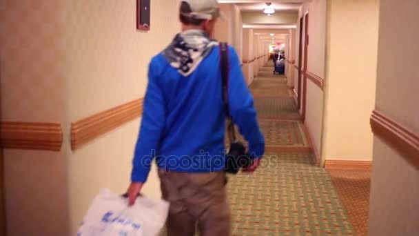 Проход в современный отель, и люди идут с сумками — стоковое видео