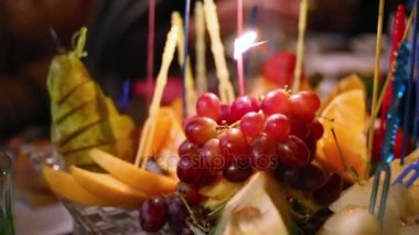 Plaka meyveleri ve yanan doğum günü mumları 