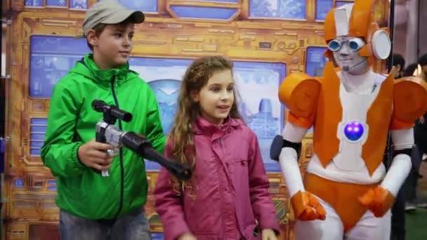 Pojke och flicka poserar med en man utklädd till transformator Rung — Stockvideo