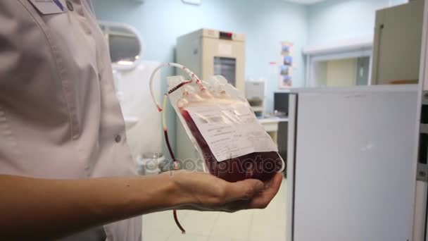 Женщина-врач держит пакет с кровью — стоковое видео