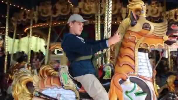ディズニーランドのメリーゴーランドの馬に乗って人々 — ストック動画