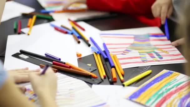 Kinderen verven handafdruk op papier bij de markeerders — Stockvideo