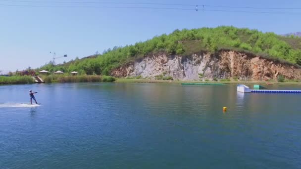 Человек перепрыгивает через препятствие во время езды на доске для серфинга — стоковое видео