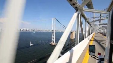 Otobüs köprünün altından metal konstrüksiyon üzerinde hızlı gidiyor.