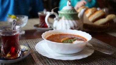 Borsch ekşi krema, bardak, çaydanlık ve buns kafede masada çay tabak.